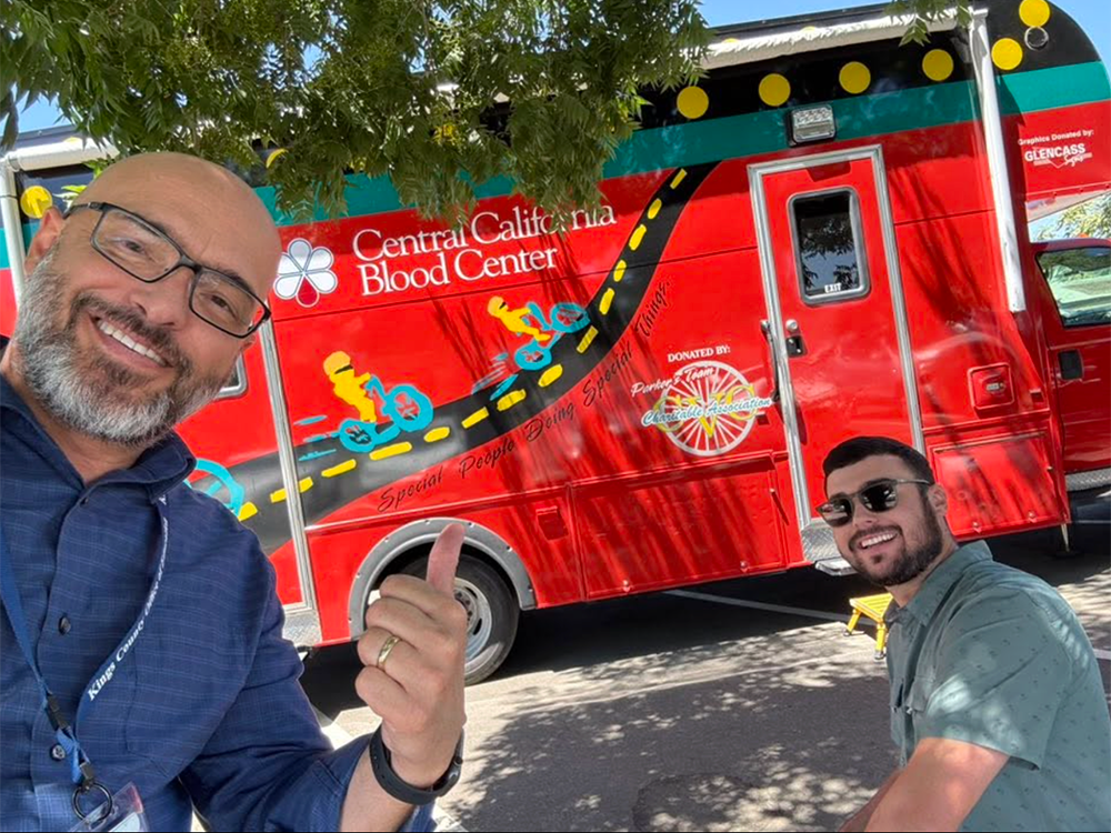 Two Rotarians smile for the camera as they wait their turn to give blood.